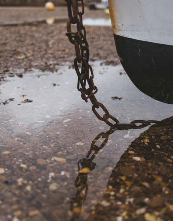 a boat is docked on land and chain attached to it