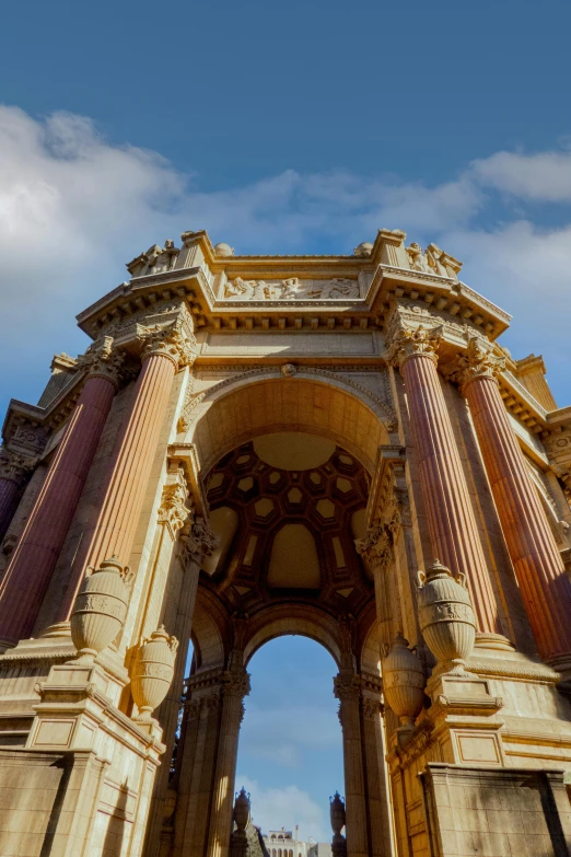 the top part of a building with tall pillars and a blue sky