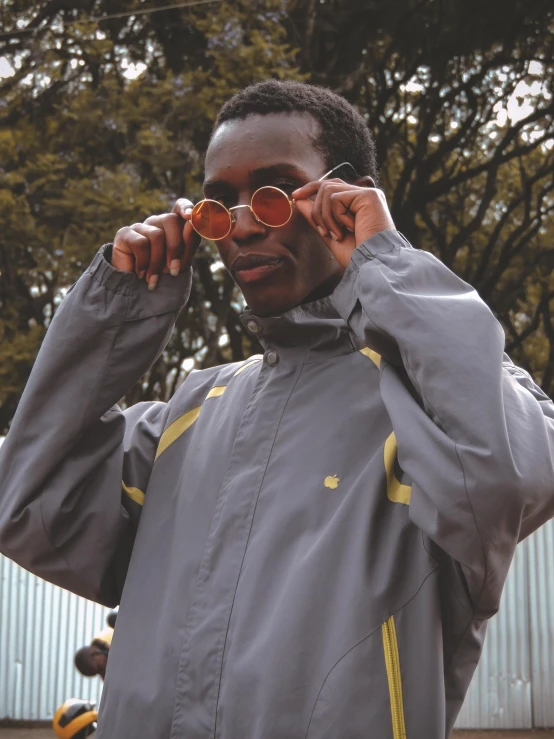 a man holds his sunglasses up as he poses for a po