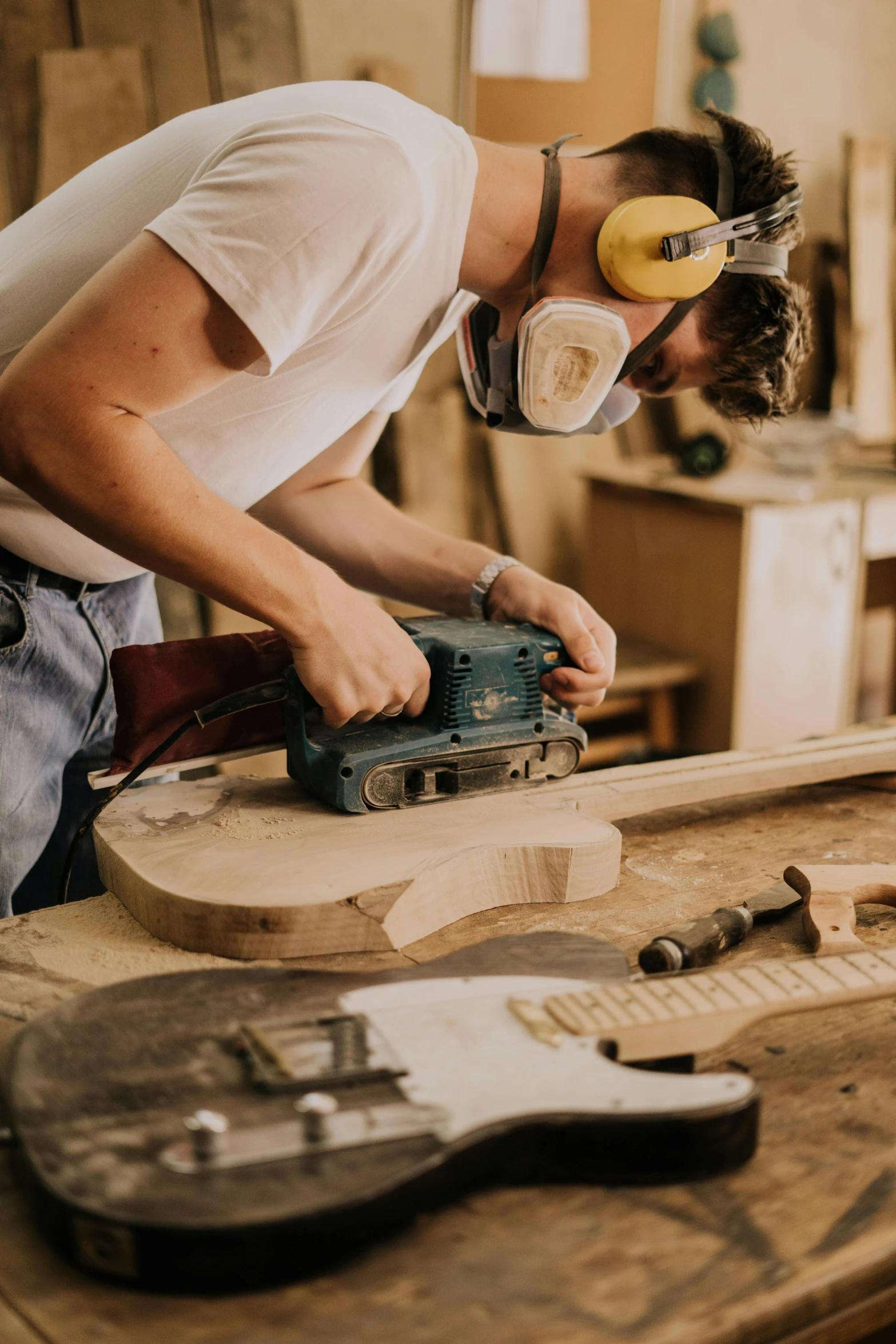 an older man sanding up furniture with a wood planer