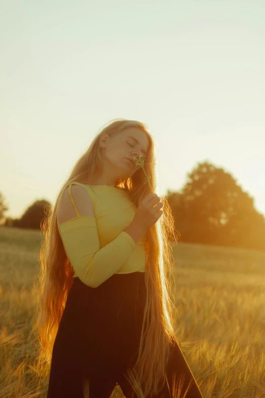 a young woman walking through a grassy field