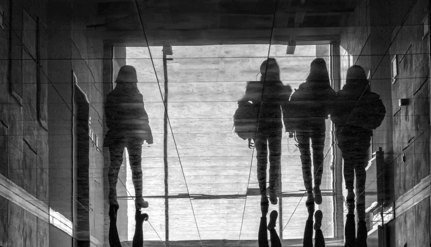 people reflected in a reflection of some very tall building windows