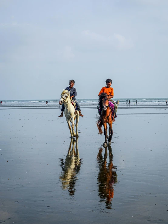 the people on horses are riding the beach in front of the water