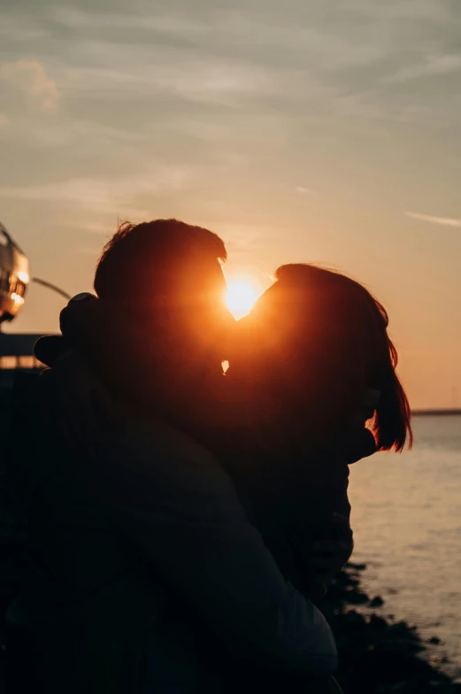 the woman kissing the man who is covering his face