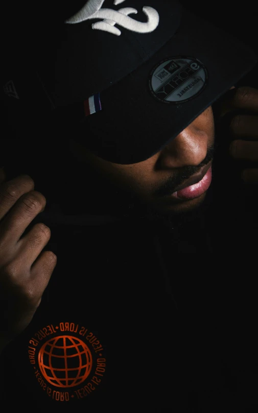 a young black man wearing a hat with white and red designs