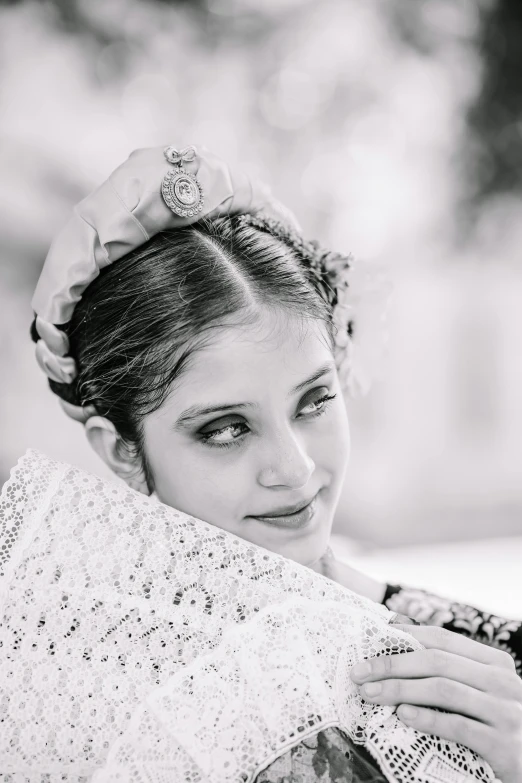 the woman wearing a veil with an embroidered sash