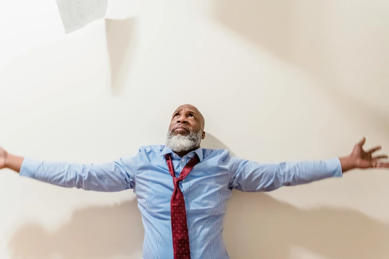 the man is wearing a red tie standing in a white room