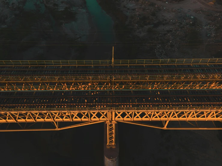 a train track is under a bridge with yellow lighting