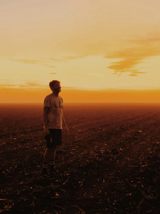 a man is standing in an open field looking at soing