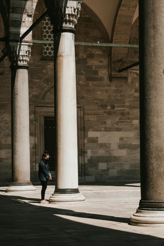 a man standing in an open doorway between two tall pillars