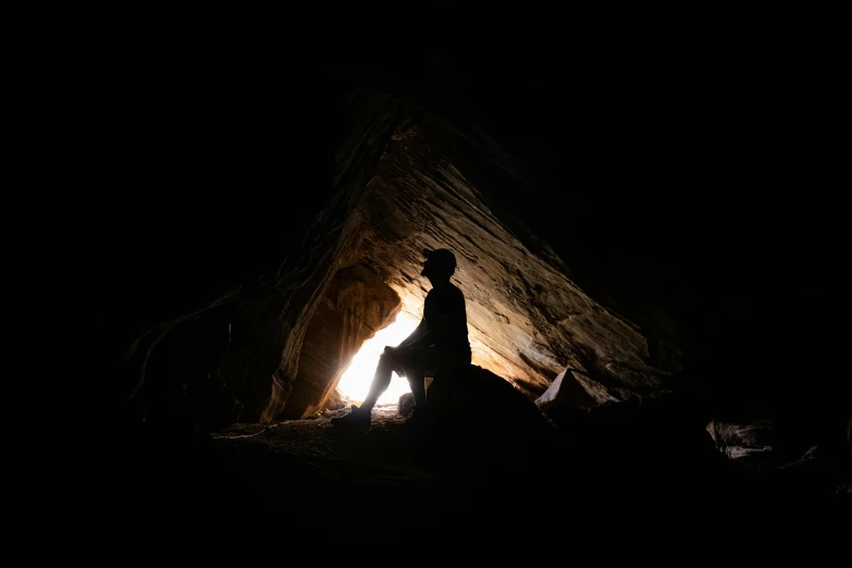 a person climbing a hill and lit by the light from a flashlight