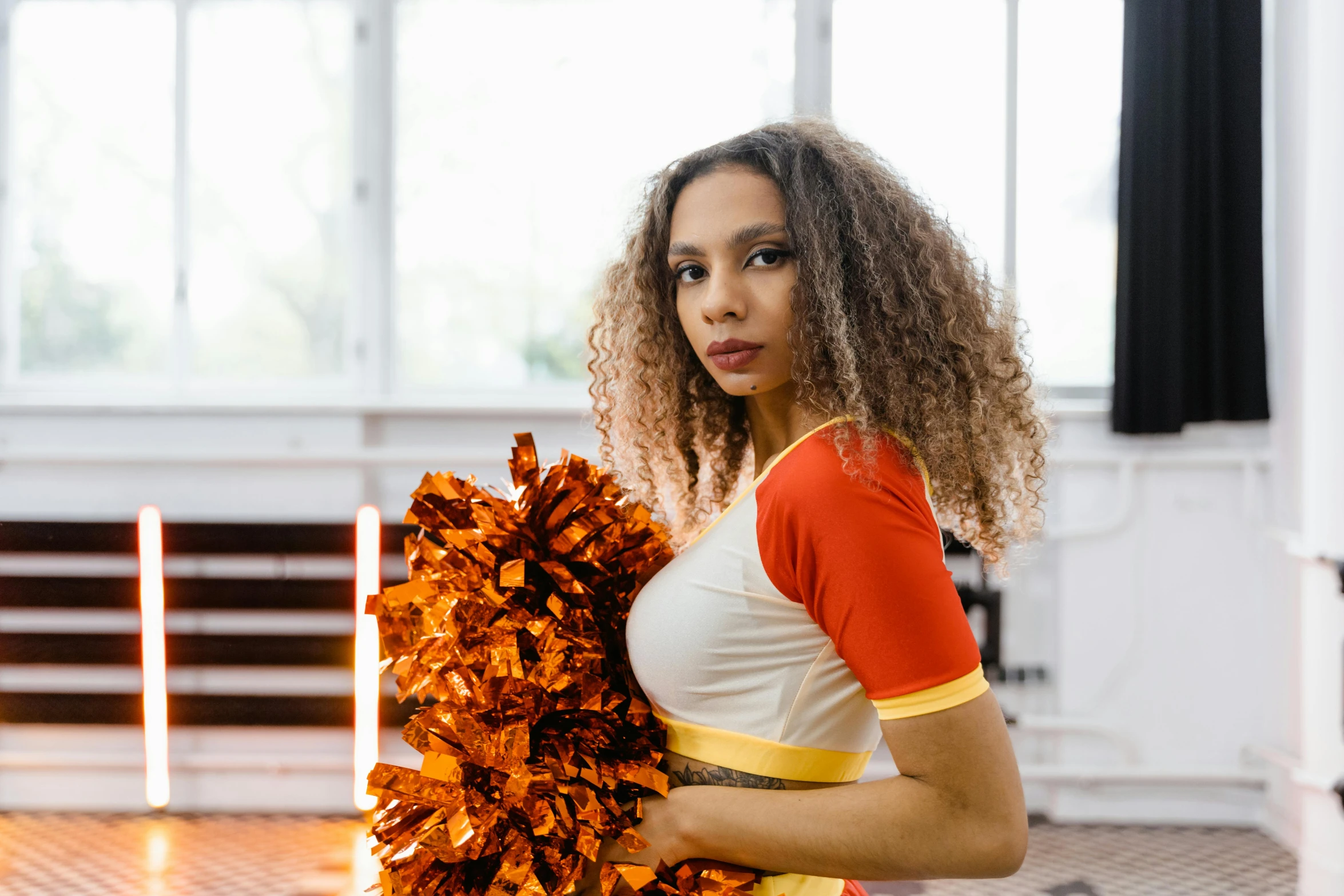 a young woman in a cheerleader uniform is holding a pom - poms