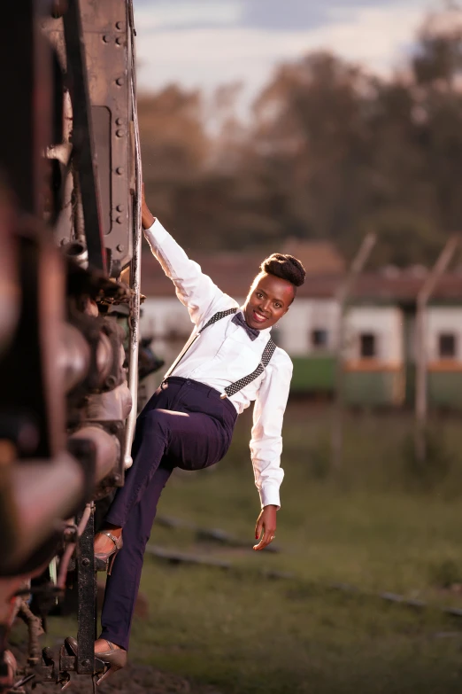 a smiling man leaning on the rails with his leg bent