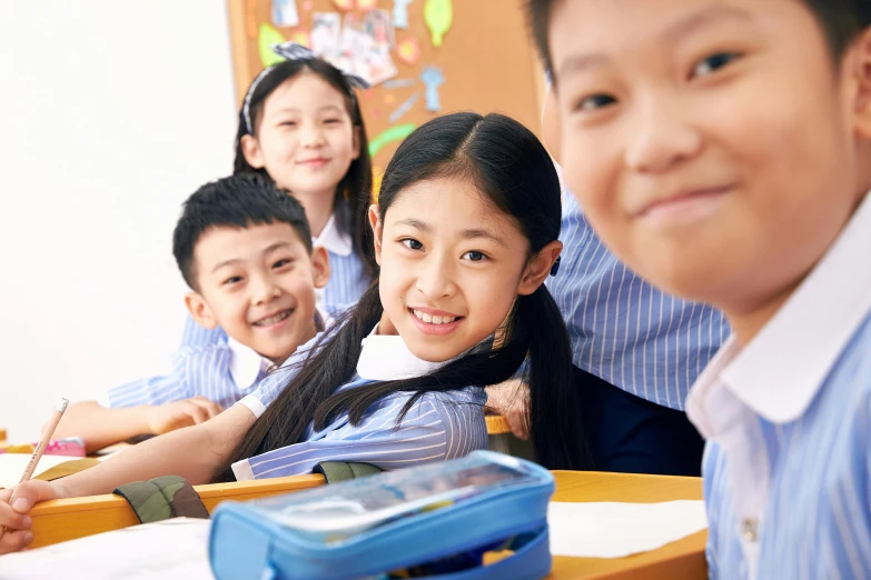 five young children in school uniforms smile for the camera