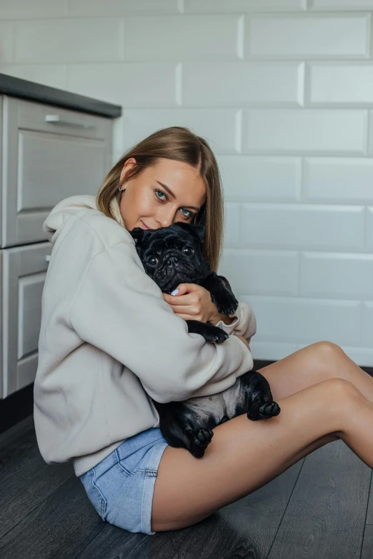 a woman sitting on the floor with her dog