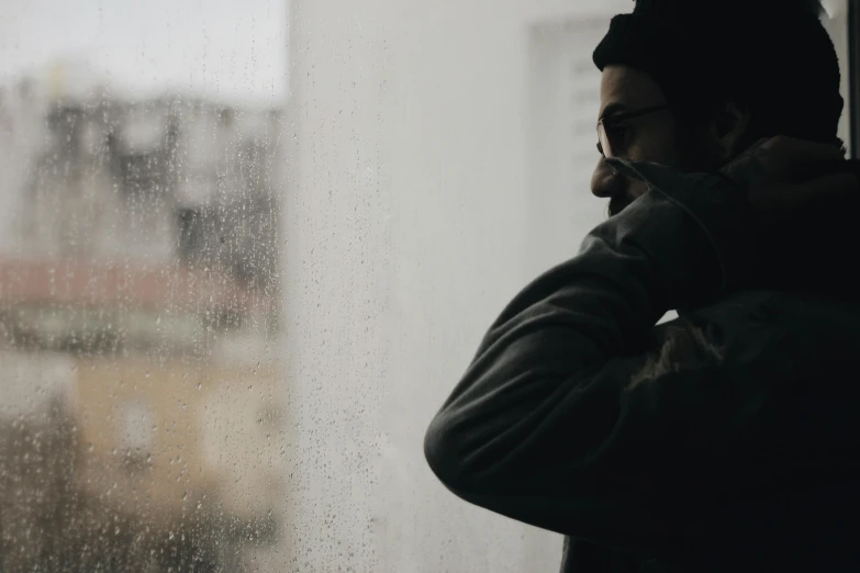 a man standing in front of a window on the phone