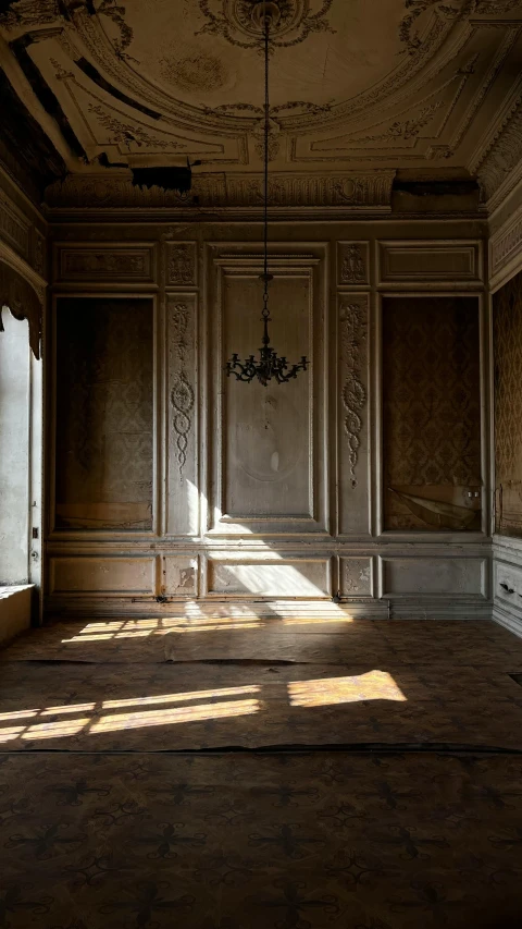 sunlight is cast through the ornate wall and ceiling inside a room with a chandelier