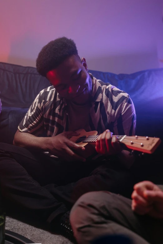 a man playing an ukulele in a house