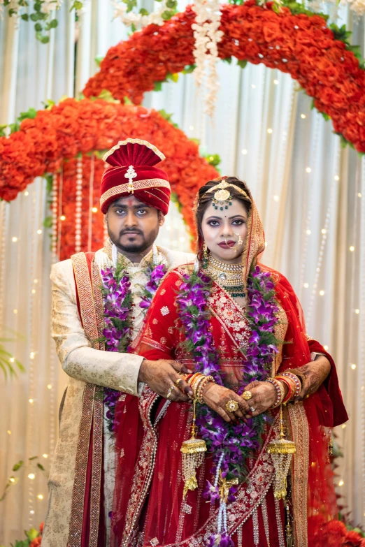 indian bride and groom pose in traditional costume for their wedding