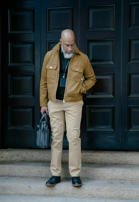 an older man standing by the door holding a black bag