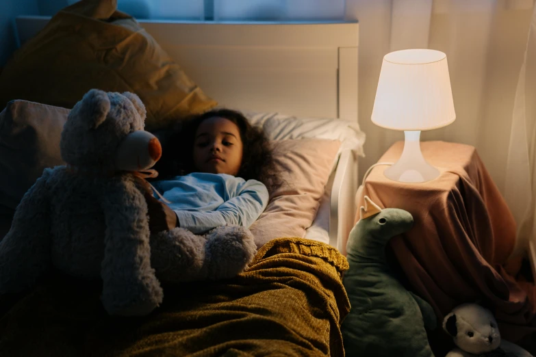 a small child asleep with a teddy bear on their chest