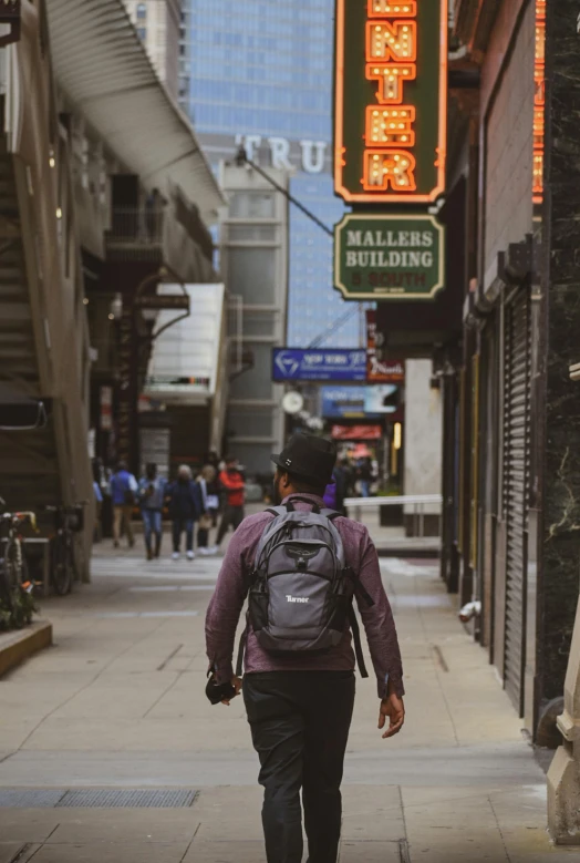 a person wearing a backpack walks down the street
