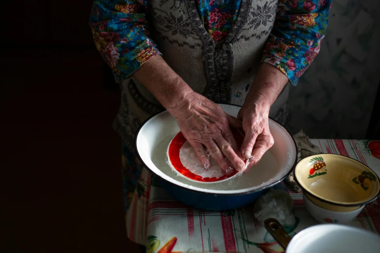 an elderly person is mixing soing in the bowl