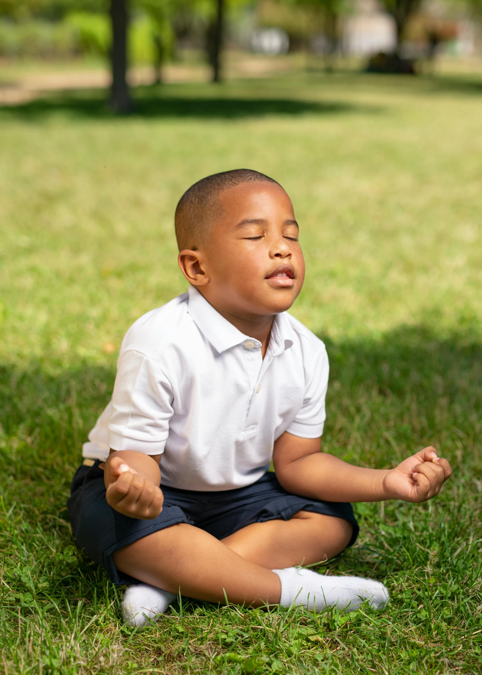 a  is sitting in the grass while practicing meditation