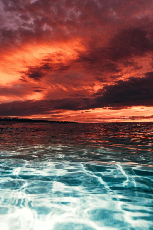 a boat that is sitting on the ocean at sunset