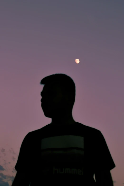 a man is holding a frisbee in front of the moon