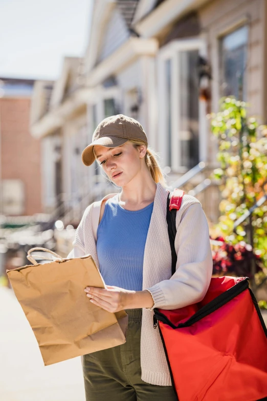 a woman walks through an alley holding a brown bag