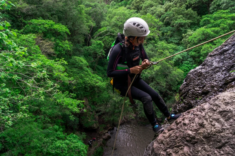 a woman rock climbing on a steep cliff