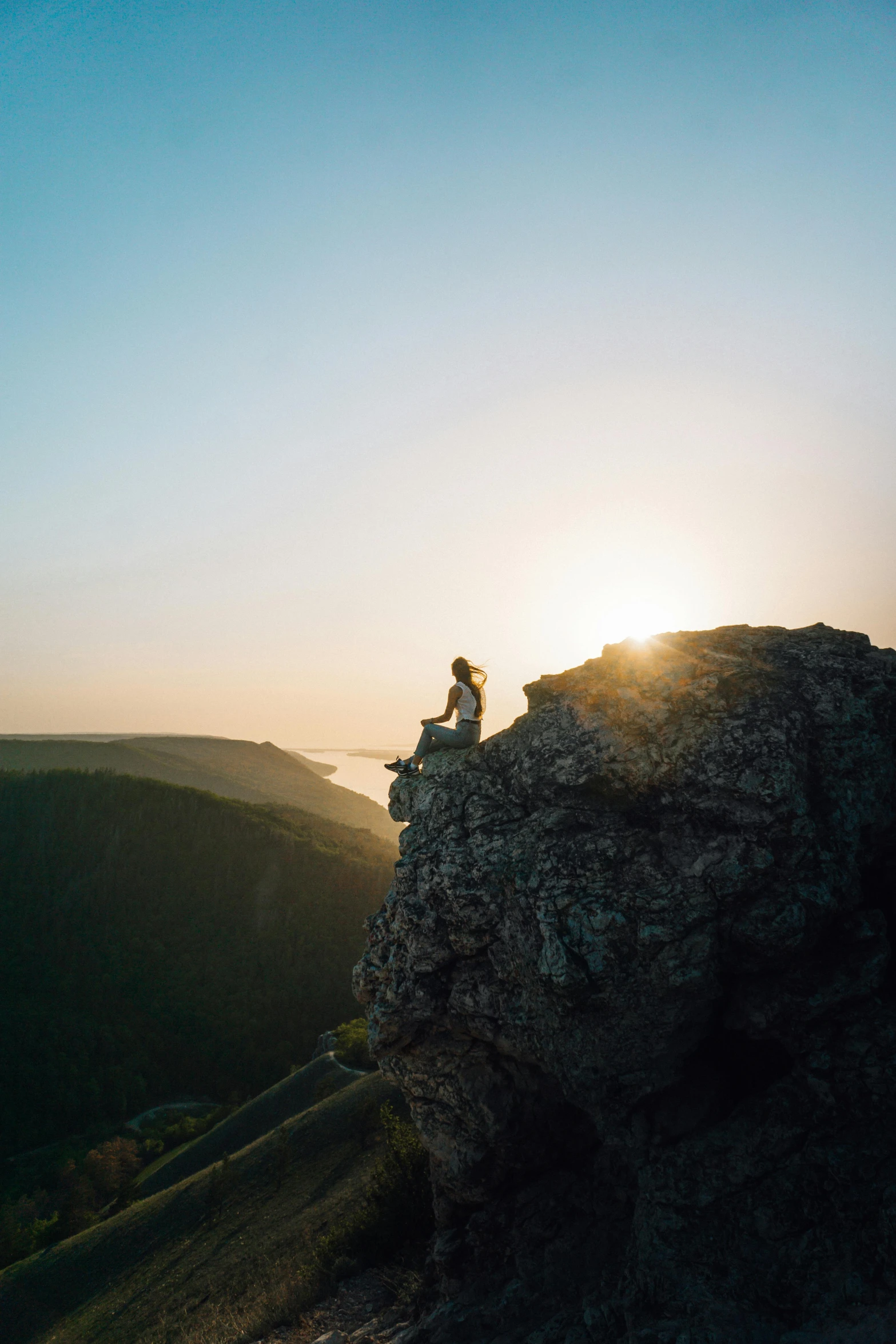 a man that is sitting on top of a cliff