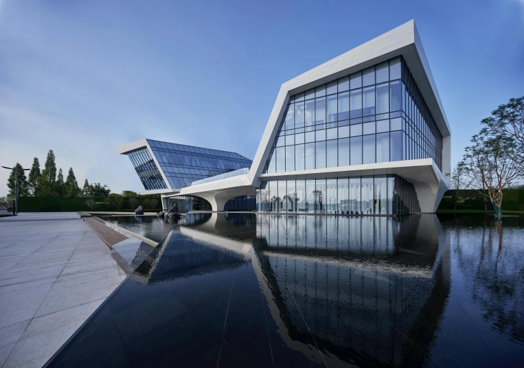 an artistic building is reflected in water on the edge