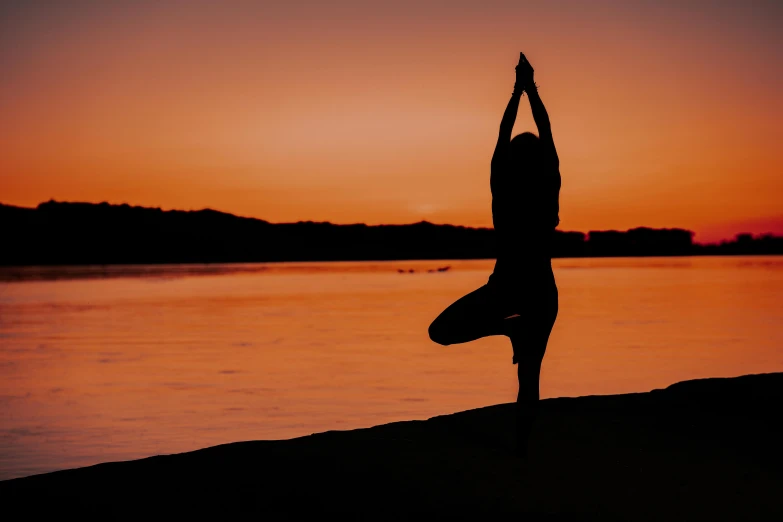 a silhouette of a person doing yoga