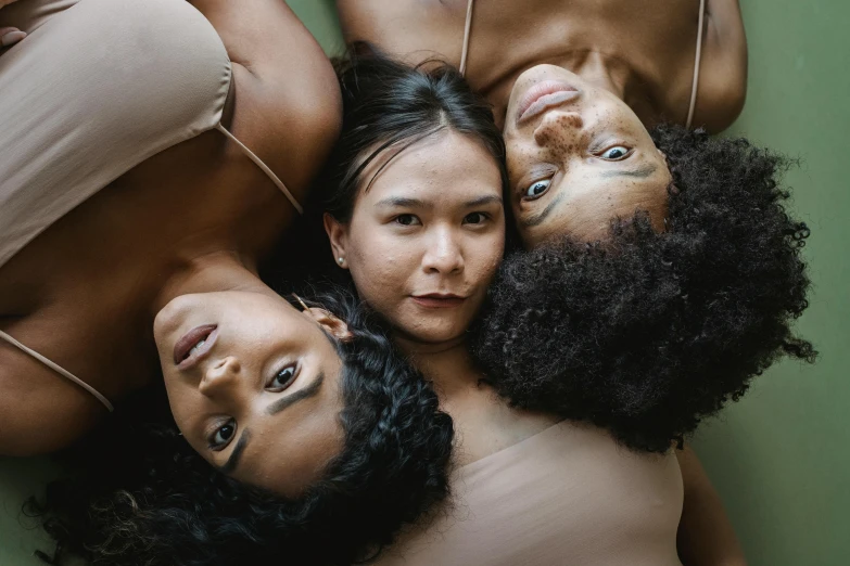 four  girls lying on the ground with one looking into the camera