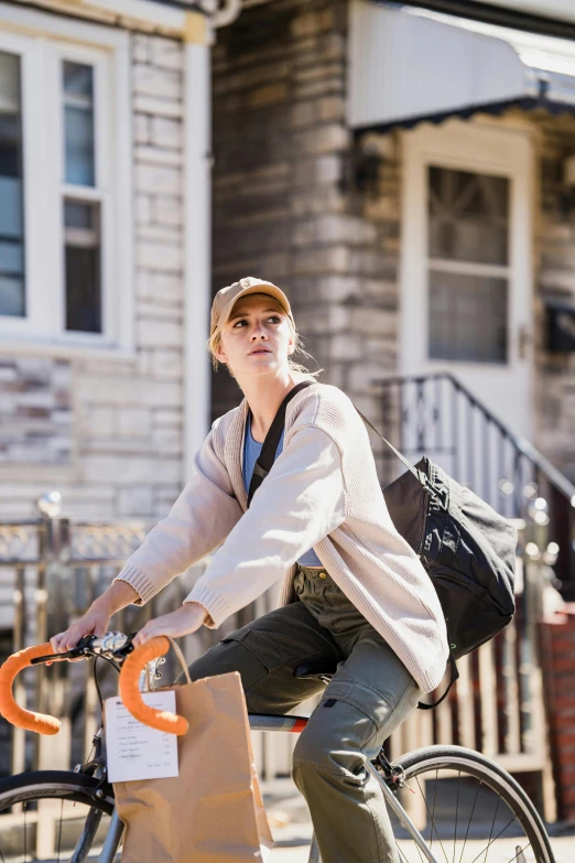 a man riding a bike past a bag and wooden buildings