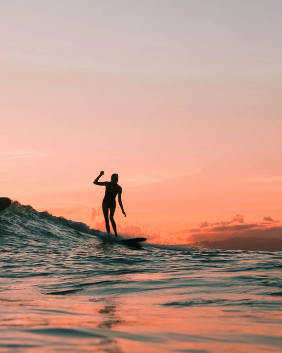 a surfer in the sunset is riding his board