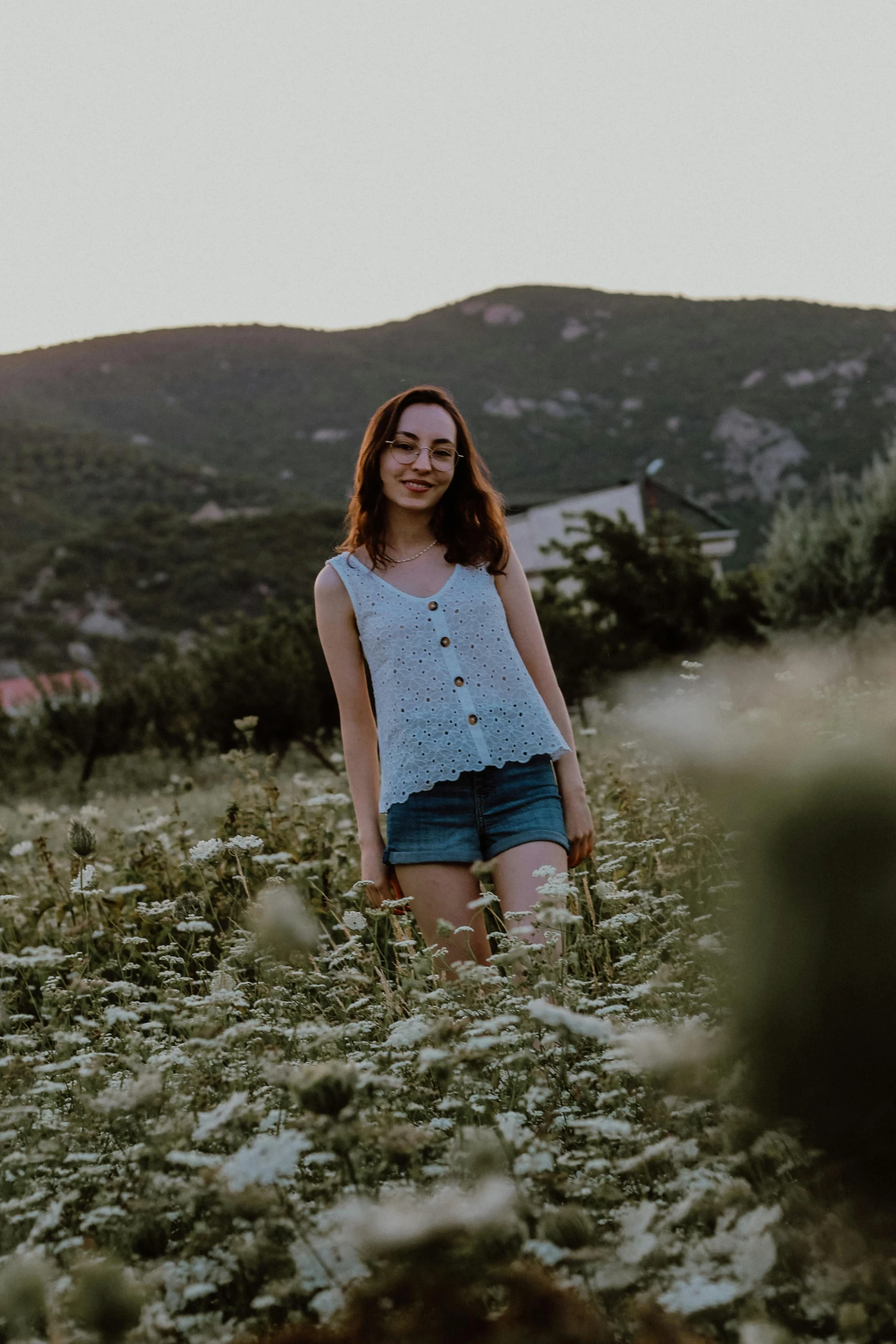 a woman in a field looking back at the camera