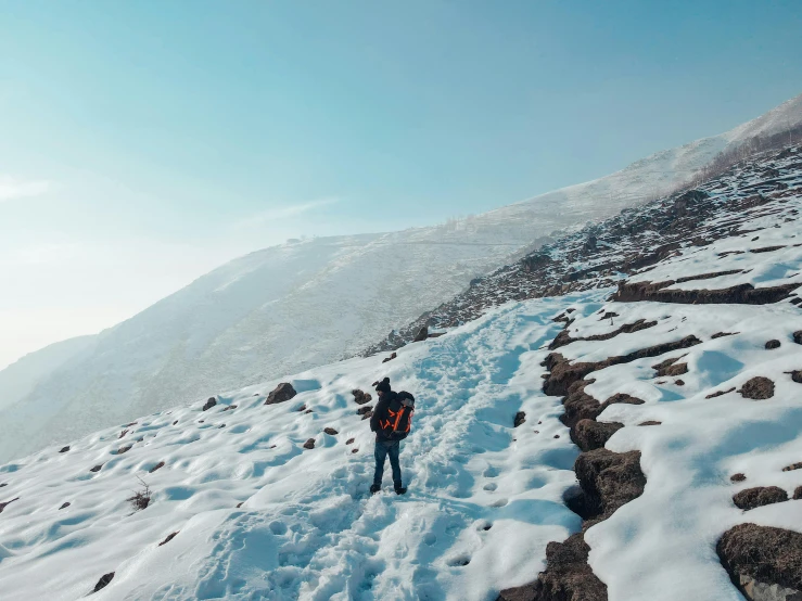 a person walks up a snow covered hill