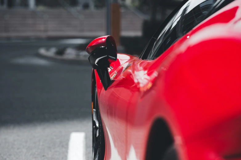 a red sports car parked next to a white curb