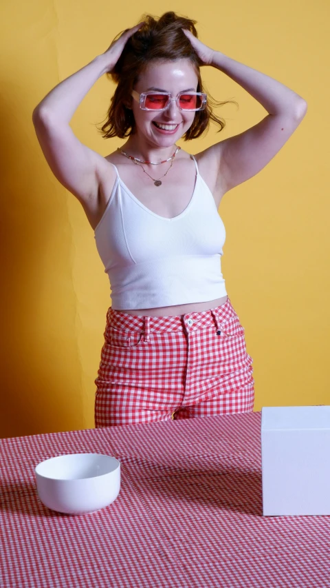 a woman is smiling and holding her hair up