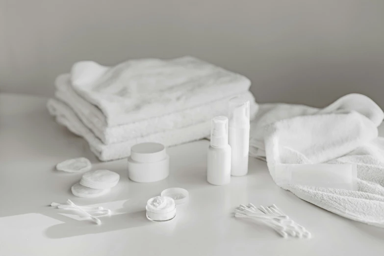 a bathroom counter with white towels and various items