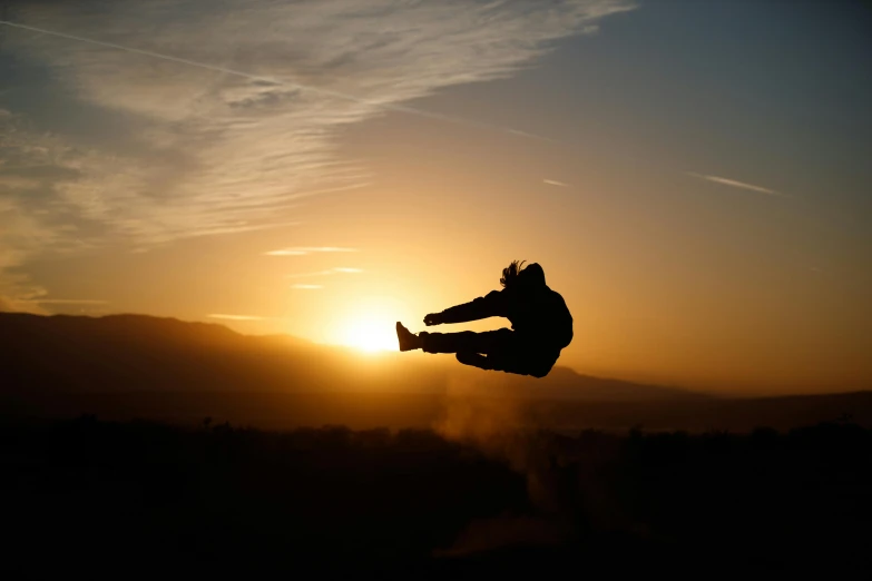 the person is doing an aerial trick in front of the sun