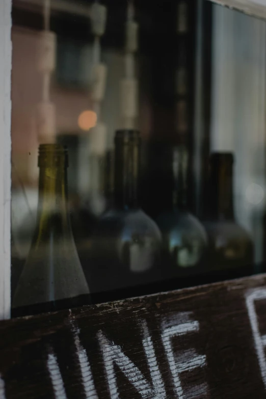 an old wine bottle and other bottles on the window sill