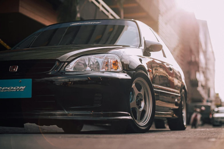 an older model honda civic is parked on the side of a street