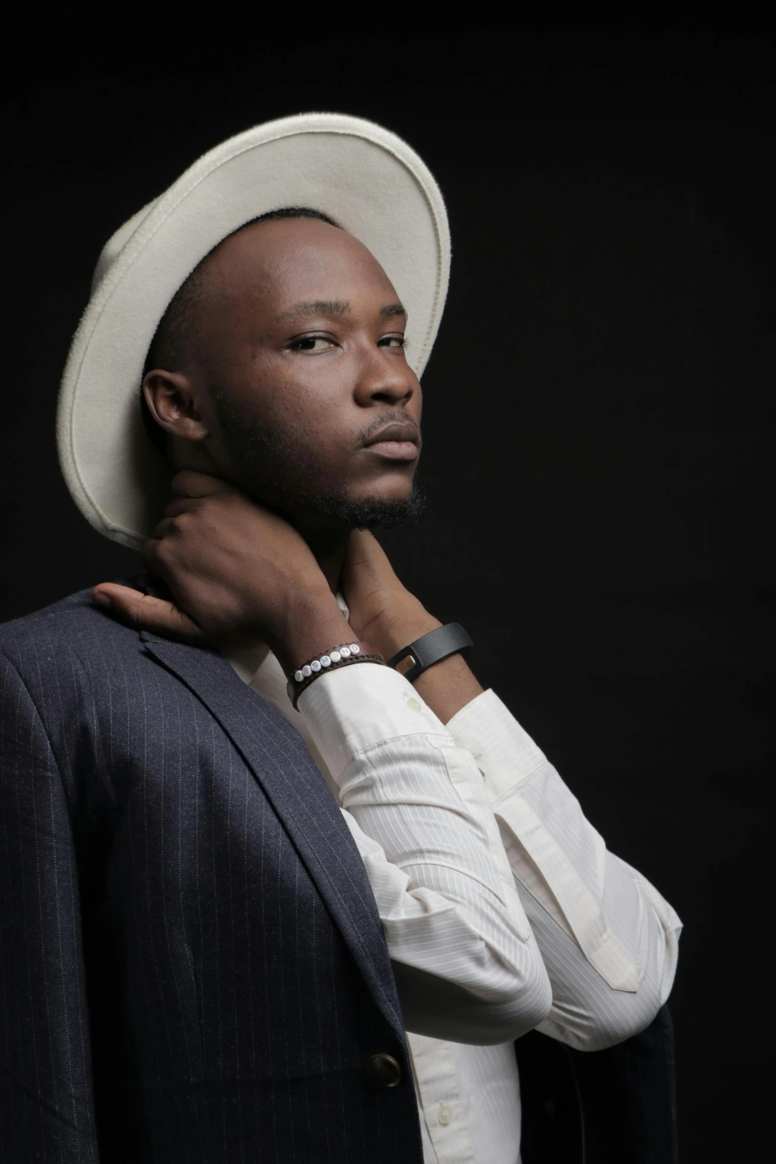 a man with a suit jacket on and a hat on