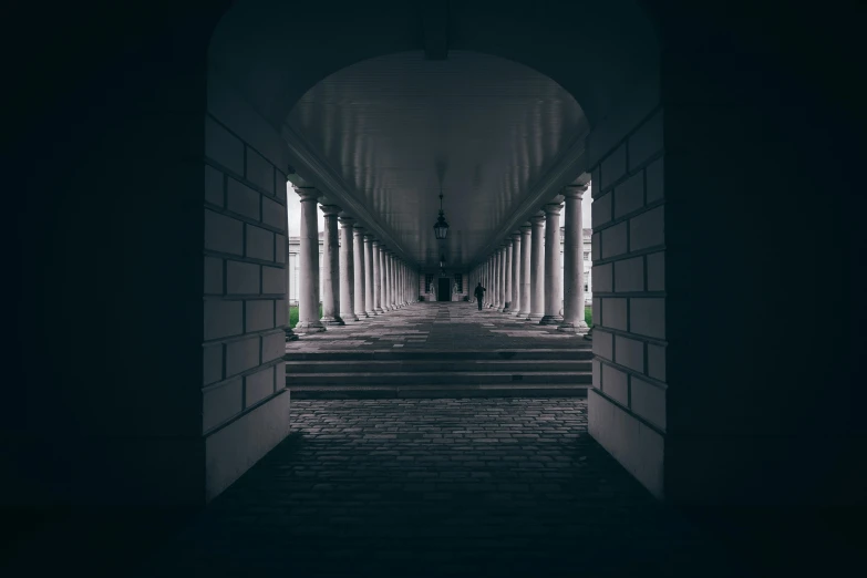 a person walking down a tunnel in a building