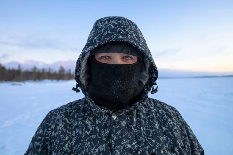 a person wearing black with a hood and head covering