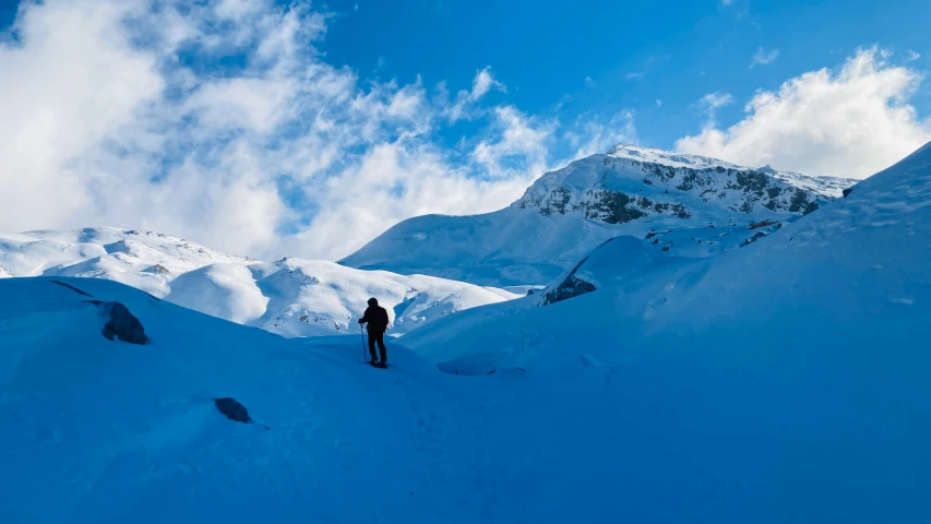 two people on skis are climbing up a mountain